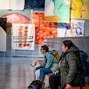 Zwei Vertrauenshundehalterinnen ruhen sich aus im Hintergrund Kunstwerke